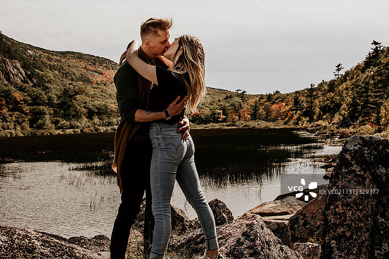 美国缅因州巴尔港，一对情侣站在湖边亲吻天空图片素材