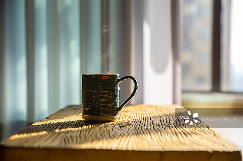 一杯热咖啡或者茶在桌子上冒着热气图片素材