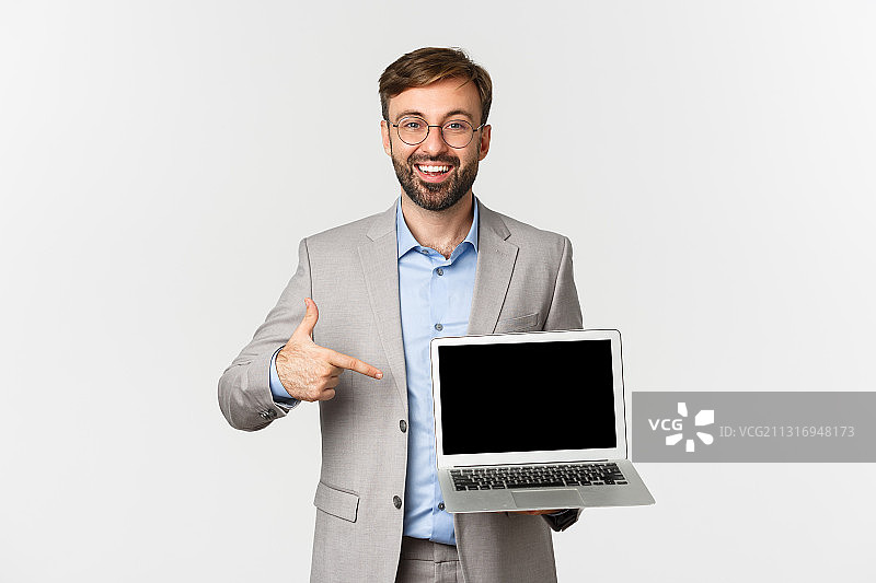 白色背景下微笑的商人拿着笔记本电脑的肖像图片素材