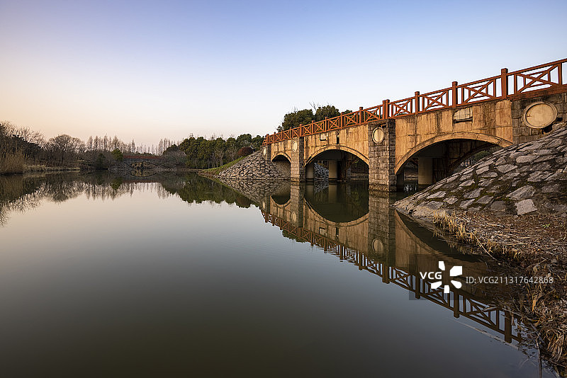 上海浦东金海湿地公园的长桥与湖面，日落时分，水面如镜图片素材