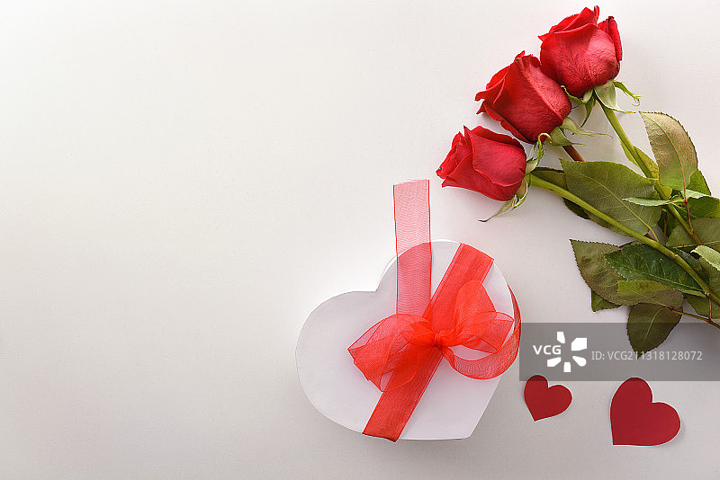 红玫瑰和礼物，白色的顶部有红色的蝴蝶结图片素材