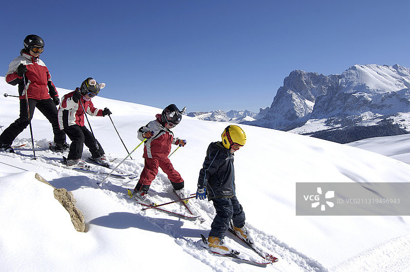 一群孩子在蓝天下滑雪，南蒂罗尔，意大利，欧洲图片素材