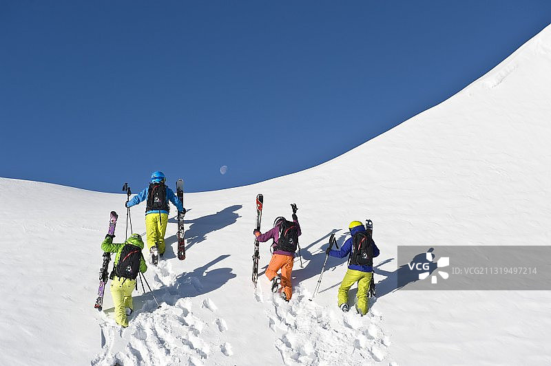 在欧洲意大利南蒂罗尔的新雪中，滑雪者正在上坡图片素材