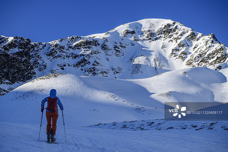 一名女子在滑雪之旅中攀登奥地利蒂洛尔斯图拜阿尔卑斯山脉图片素材