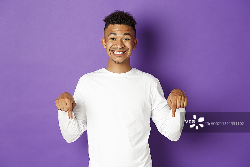 微笑的年轻人的肖像持有紫色的粘液站在紫色的背景图片素材