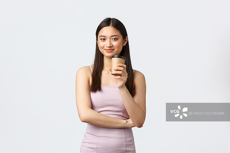 白色背景下的年轻女子举着奶瓶的肖像图片素材