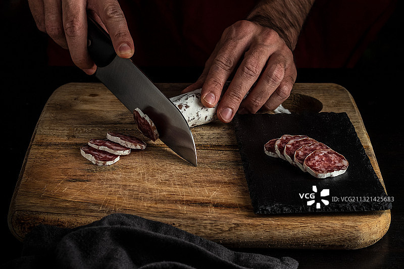 休达，西班牙，男人在砧板上切肉的腹部图片素材