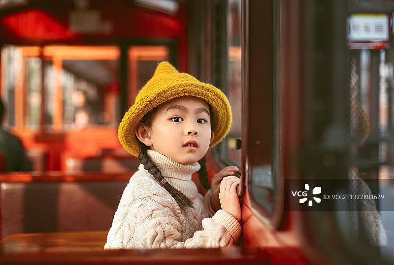 火车上手扶窗户往外看的小女孩图片素材