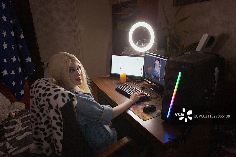 戴着假发的年轻女性网红的肖像，用电脑在线流媒体，俄罗斯萨拉托夫图片素材