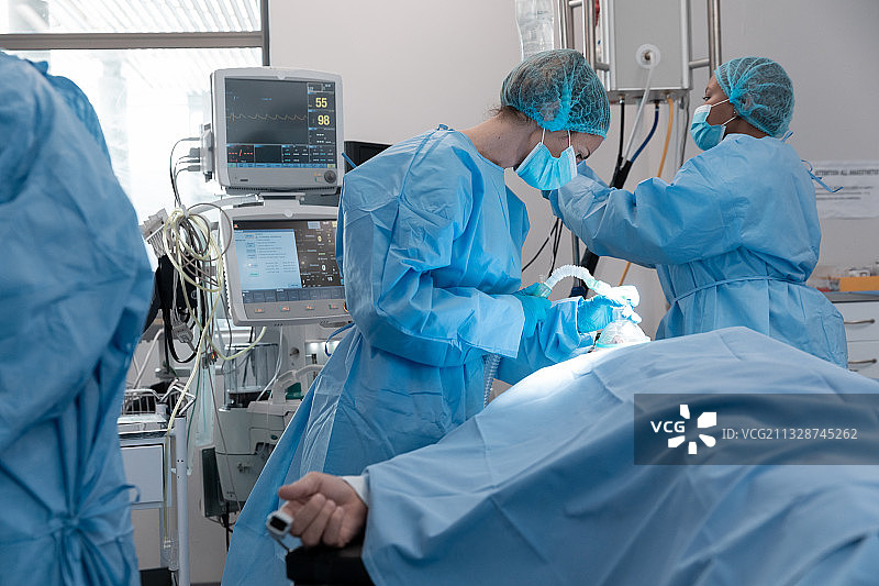 白种女外科医生戴面罩给躺在床上的病人戴氧气面罩图片素材