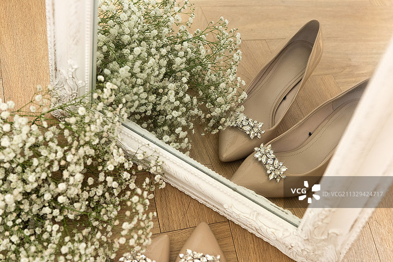 一束鲜花和婚礼鞋对着镜子图片素材