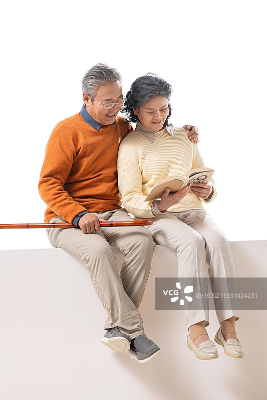 老年夫妇坐在一起看书图片素材