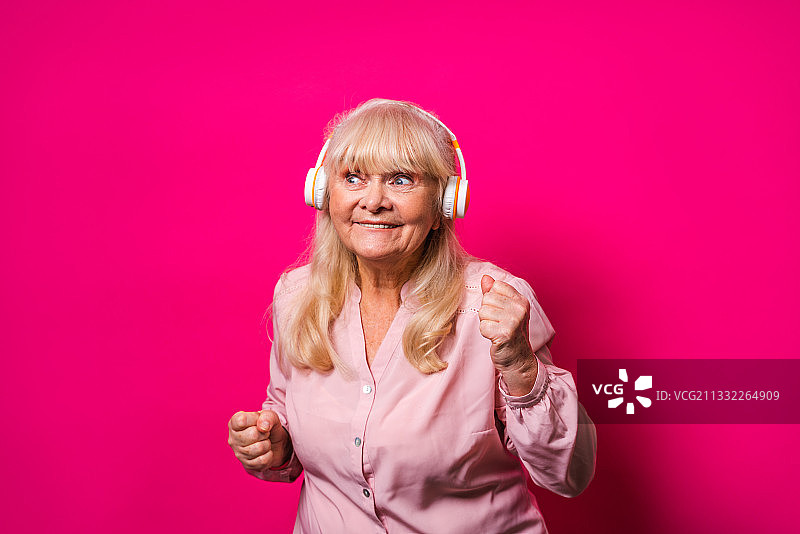 肖像微笑的妇女听音乐的粉红色的背景图片素材