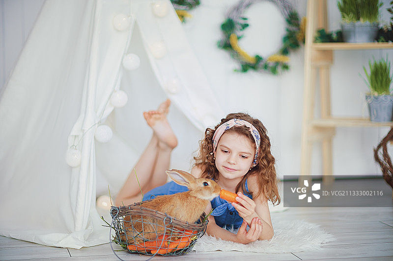 复活节小女孩和宠物兔子的肖像图片素材