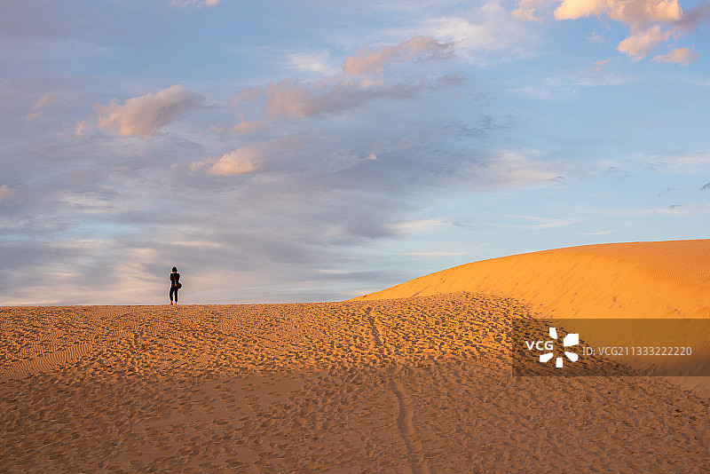 南非伊莉莎白港，一名行走在沙漠沙丘上的男子图片素材
