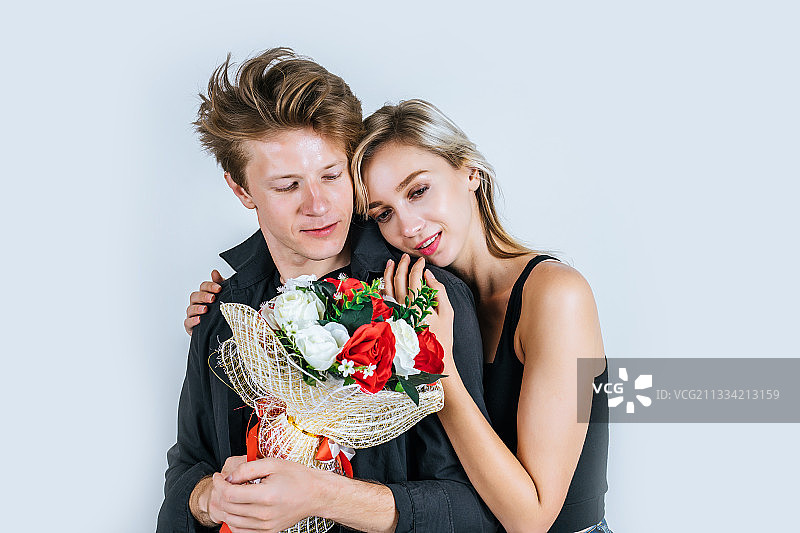 肖像幸福的年轻夫妇爱在一起与花在工作室图片素材