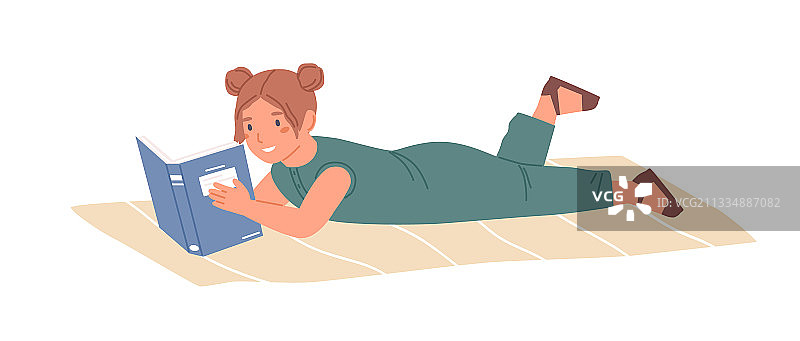 快乐的女孩躺在地毯上看书图片素材