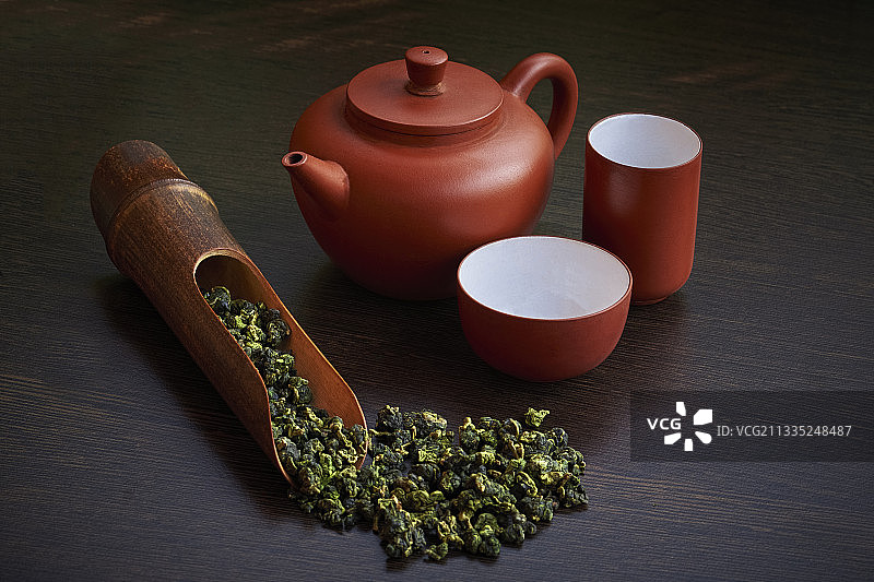 高角度的草药茶与茶壶和叶子在桌子上图片素材