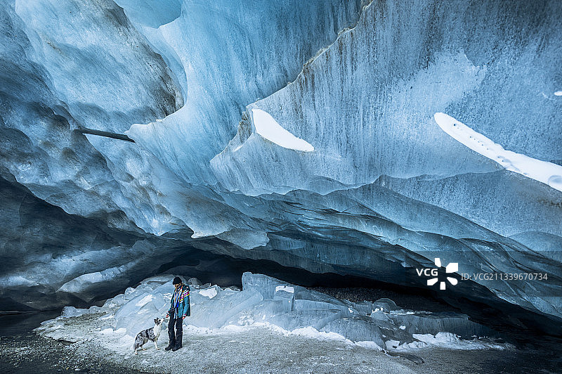 一个女人探索一个令人惊叹的冰川冰洞，Zinal，艾耶，瑞士图片素材