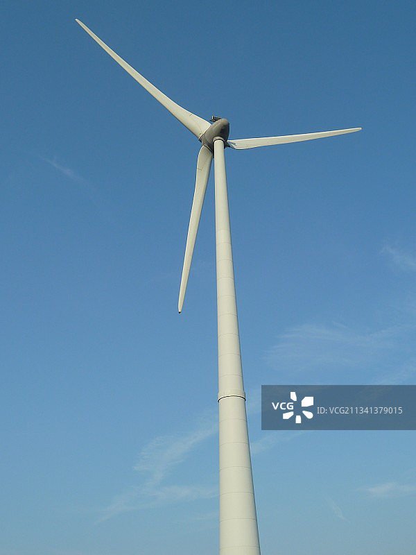 蓝天下风力涡轮机的低角度视图图片素材
