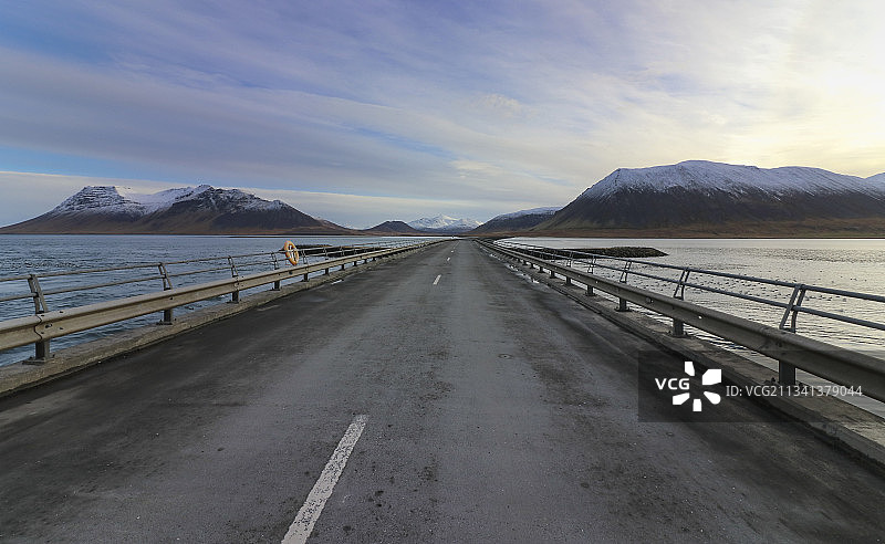 冰岛，空无一人的道路通向天空下的群山图片素材