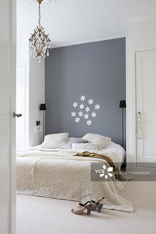 在简单的卧室里，床靠在灰色的墙壁上，在两个衣橱之间图片素材