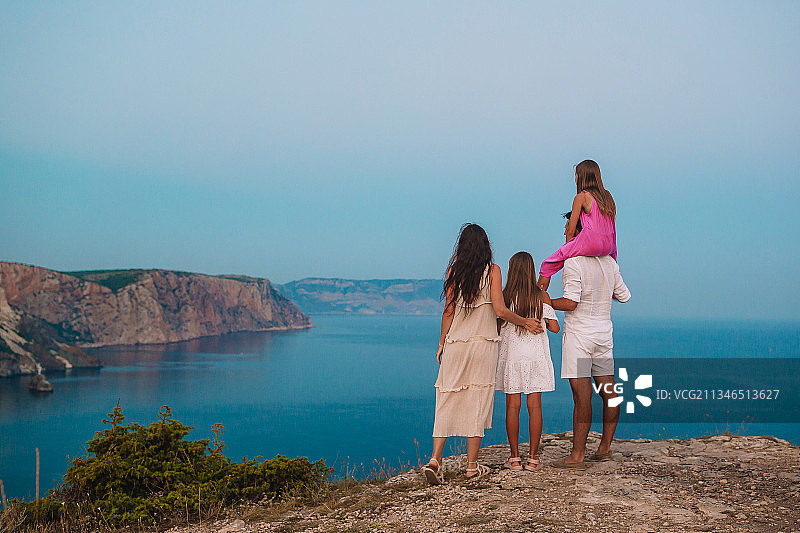 一家人站在海天相望的悬崖上图片素材