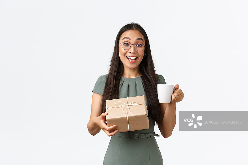 面带微笑的女商人手持咖啡杯，站在白色背景下图片素材
