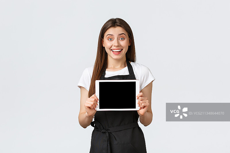 微笑的年轻女子的肖像手持数字平板电脑在白色的背景图片素材