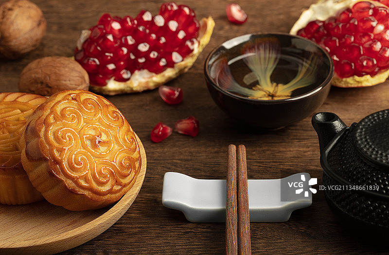 中秋节木桌上的石榴核桃月饼与茶图片素材