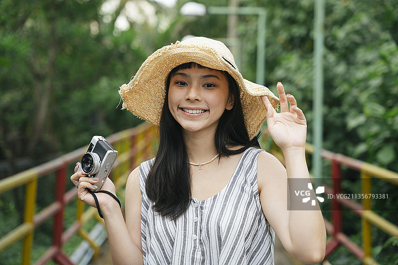 年轻亚洲女人的时尚肖像与复古相机。美丽的摄影师在度假村。图片素材