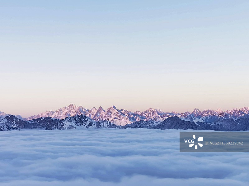 日出时白雪皑皑的群山景色图片素材