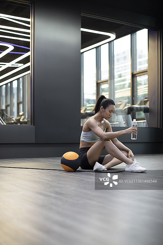 年轻女士在健身房健身后休息图片素材