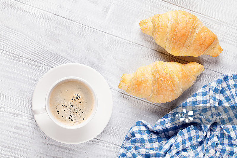 新鲜的牛角面包和咖啡，餐桌上早餐的高视角图片素材