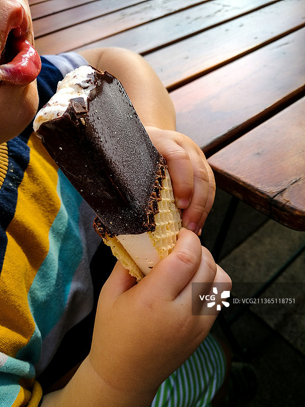 男孩吃冰淇淋的半腰图片素材