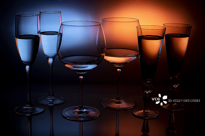 彩色眼镜，近距离的葡萄酒酒杯在桌子上的黑色背景图片素材