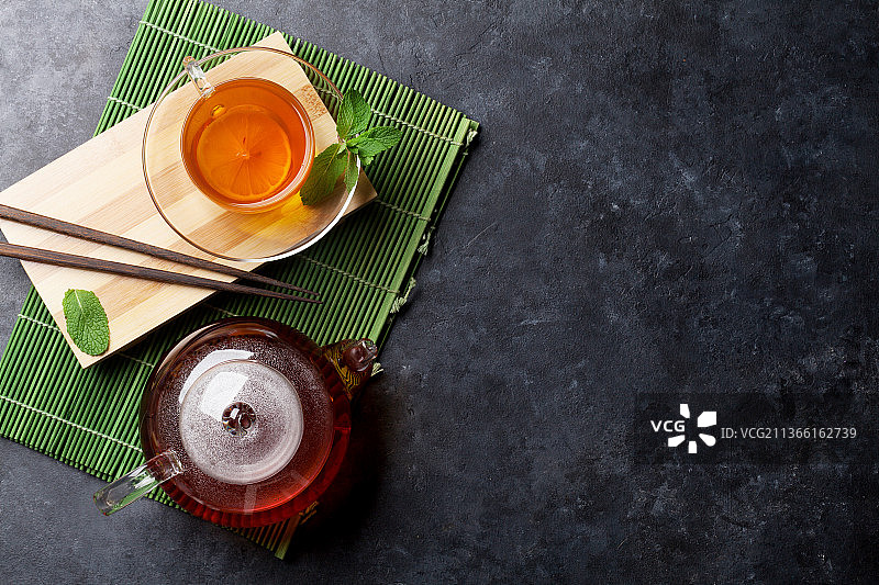 茶杯和茶壶，在桌子上食物的正上方图片素材