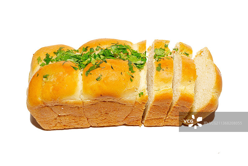 金黄的新鲜面包，白色面包上点缀着绿色蔬菜图片素材