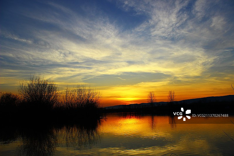 湖上日落，日落时天空映衬下的湖景图片素材