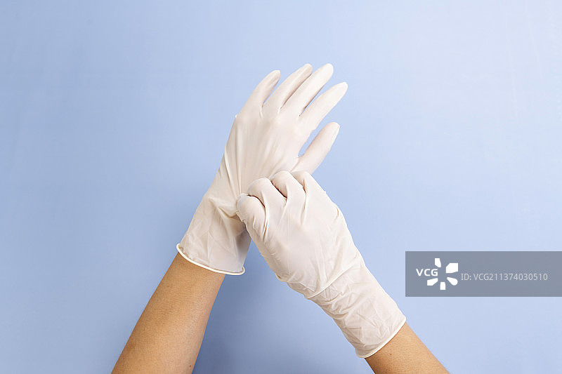 双手佩戴一次性医用乳胶手套图片素材