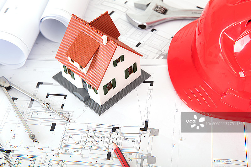 工程图纸和房子模型及一个红色安全帽及其它相关工具图片素材