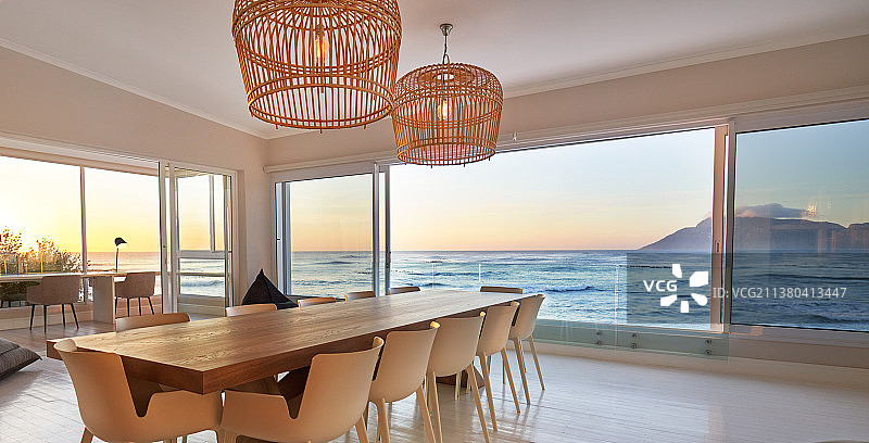 藤条吊灯挂在餐桌上，可以欣赏美丽的海景图片素材