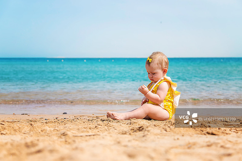 婴儿在海滩附近的大海选择性集中图片素材