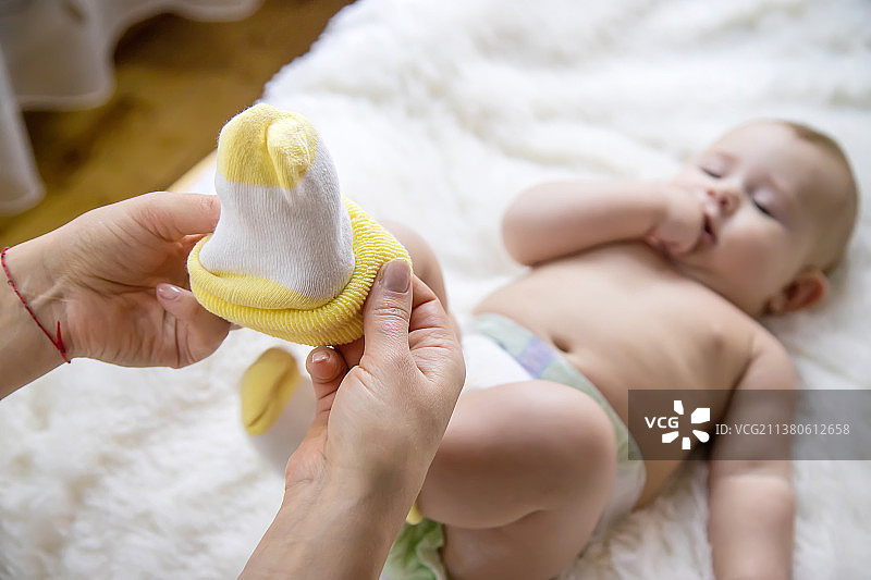 妈妈把袜子放在宝宝身上选择性聚焦图片素材