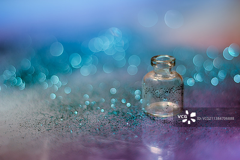 近距离的玻璃瓶闪光和蓝色花束灯在桌子上图片素材