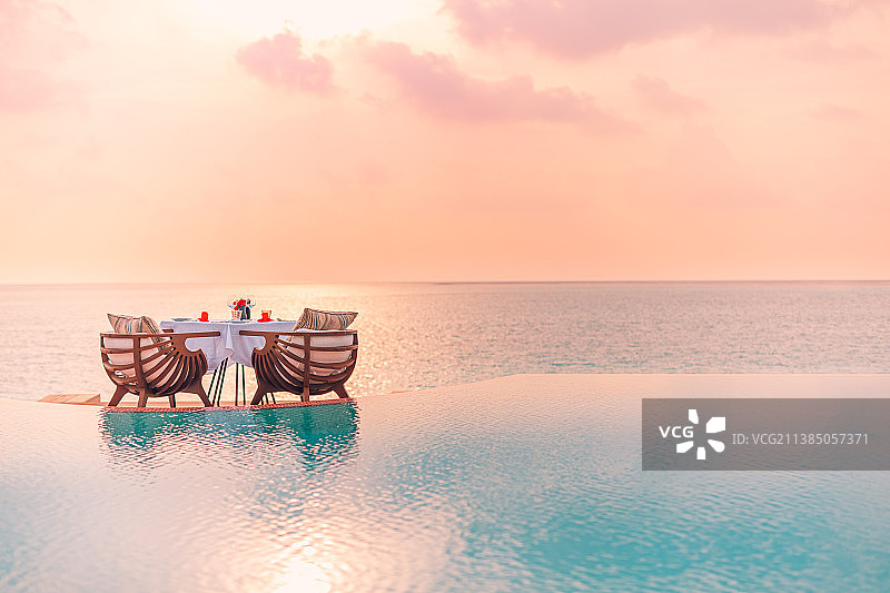 在海滩上的空椅子和桌子的景色，在日落时的天空浪漫的概念，马尔代夫图片素材