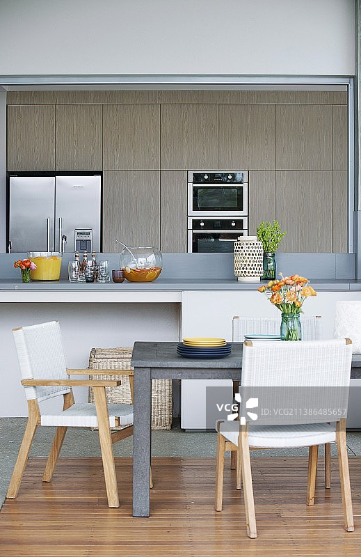 餐桌和椅子与白色，织布座位前的柜台在灰色和白色安装厨房图片素材