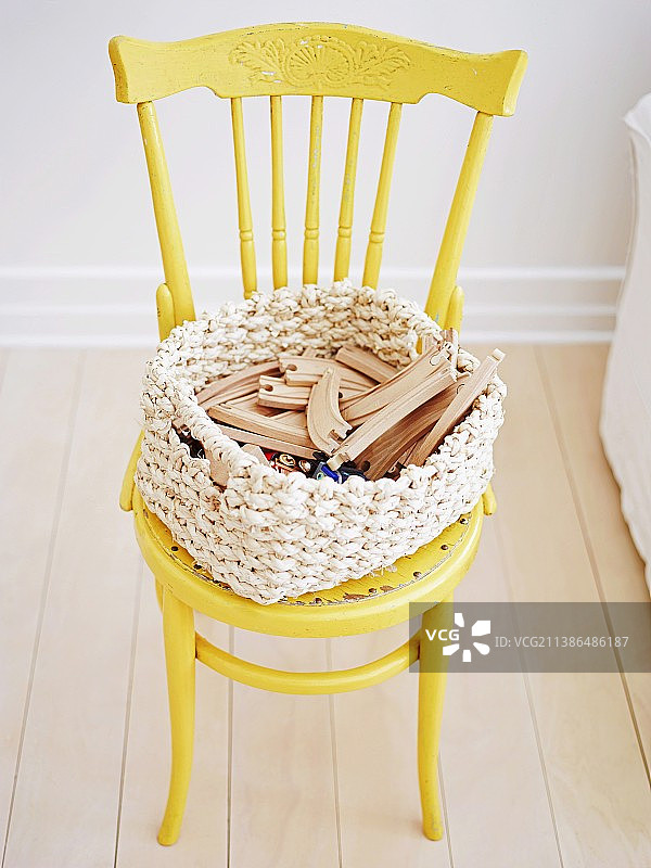 木制玩具放在黄漆托内椅的篮子里图片素材