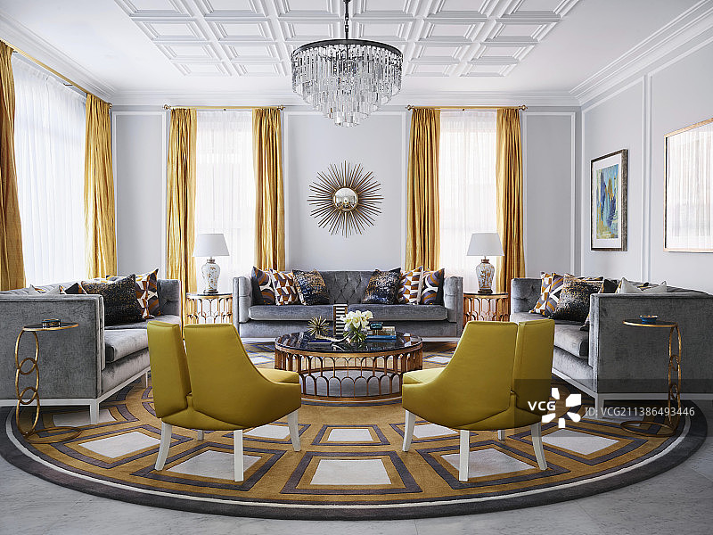 豪华的客厅里，金色的设计师椅子和灰色的沙发，大理石桌子周围有天鹅绒装饰图片素材