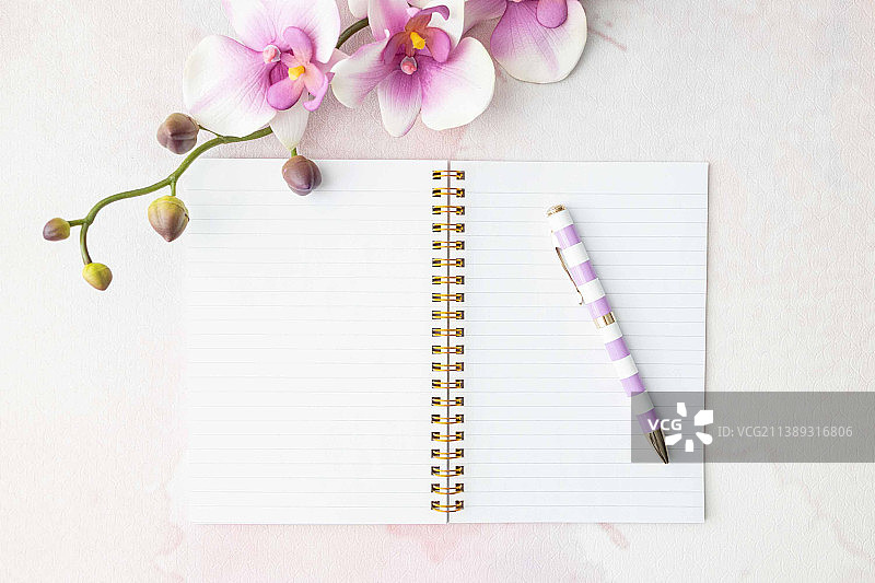 高角度的空白笔记本与花和笔在桌子上图片素材